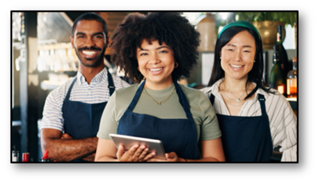 A group of people wearing aprons are posing for a picture.