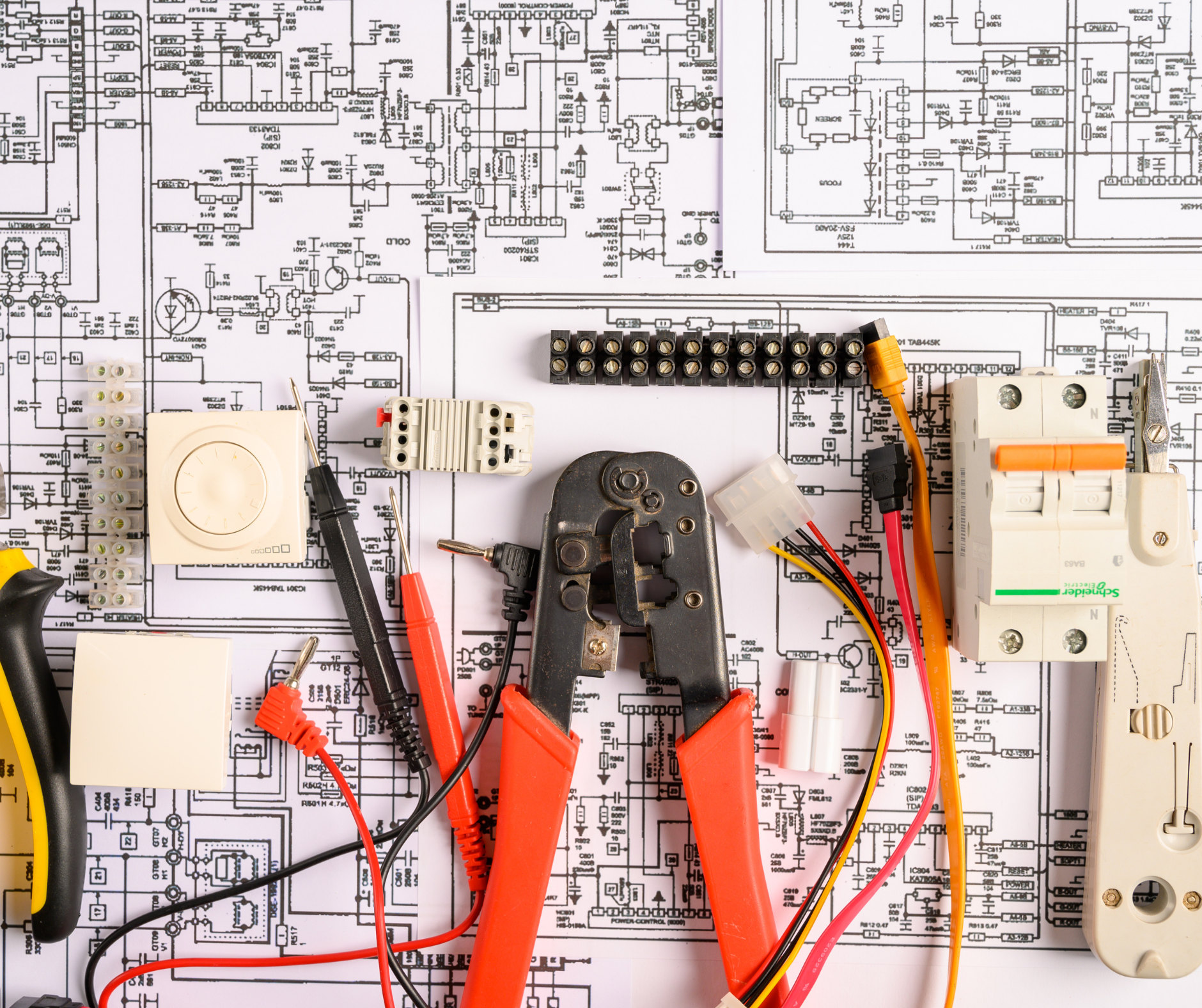 Electrical components and tools on top of an electrical schematic.
