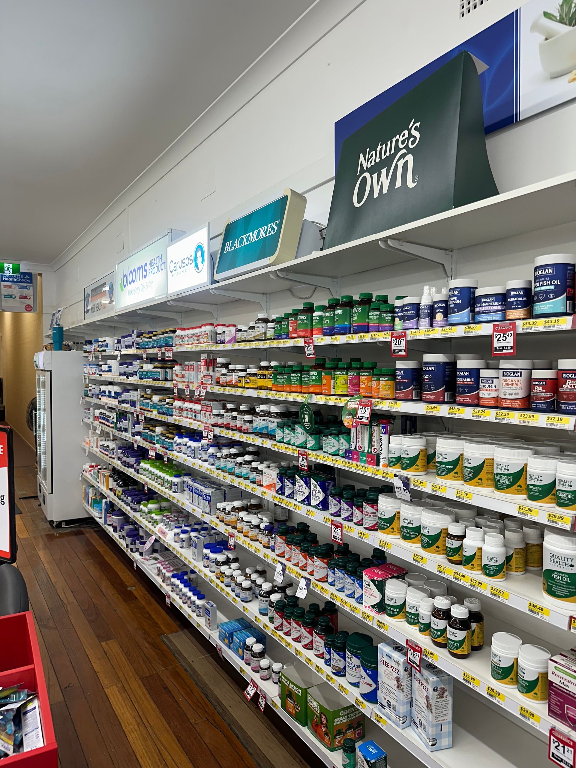 Shelves stocked with various supplements in a brightly lit store. The products are in colorful bottles and jars.