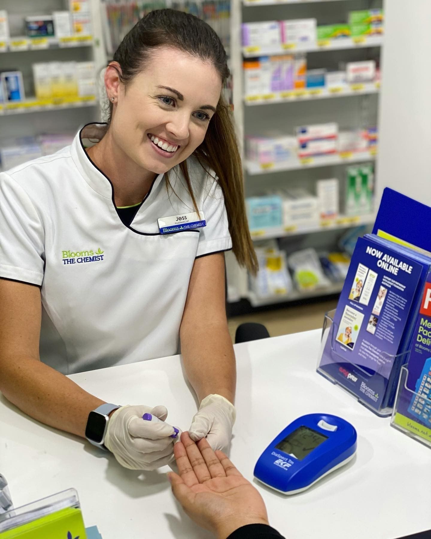 Woman in Hijab Pays at Pharmacy Counter — Blooms The Chemist Sawtell in Sawtell, NSW