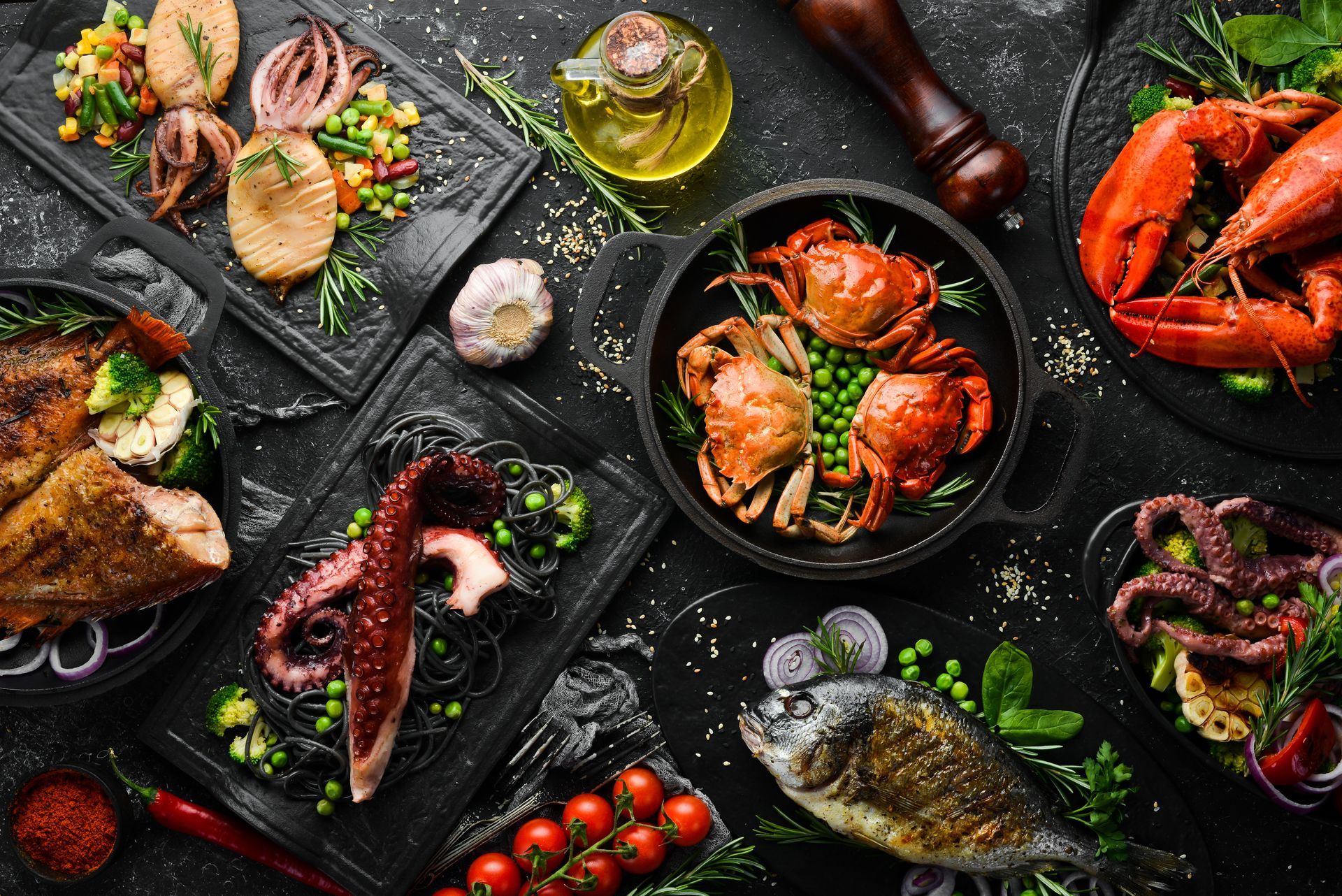 Seafood assortment on dark slate plates: shrimp, mussels, crab, octopus, lemon, and herbs Seafood assortment on dark slate plates: shrimp, mussels, crab, octopus, lemon, and herbs
