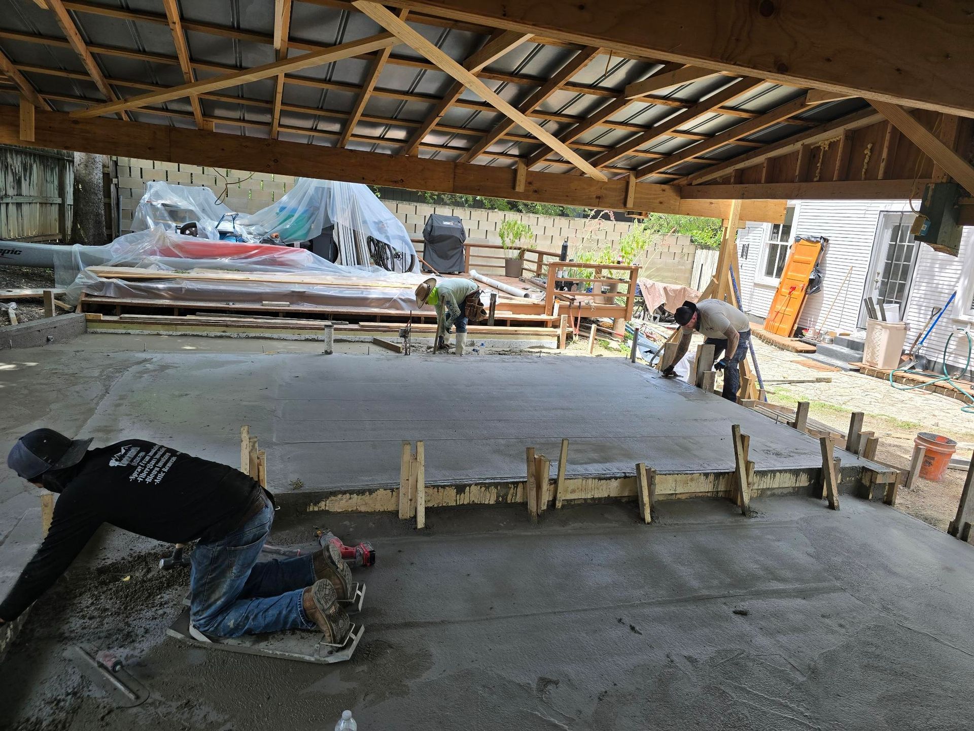 An empty barn with a concrete floor and a wooden roof. Project done by Raise the Bar Construction