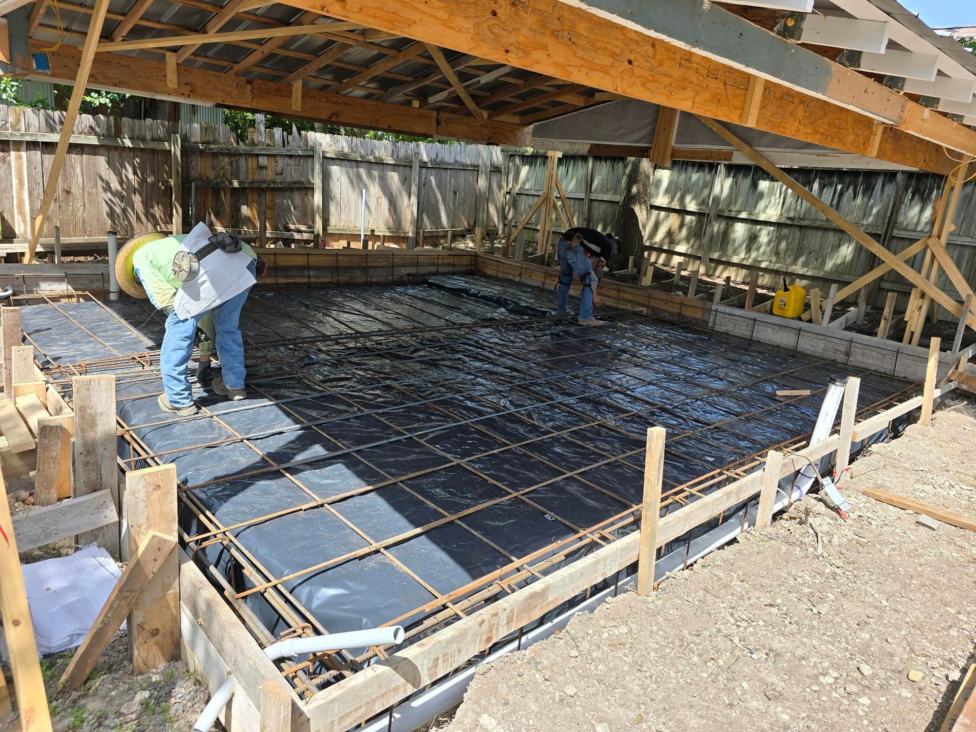 A large empty room with concrete floors and columns in a building under construction.