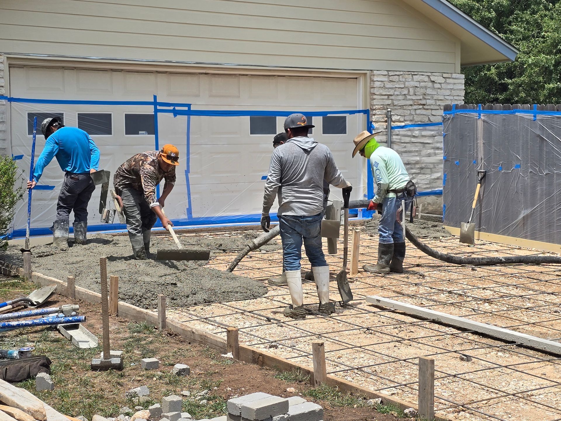 A concrete walkway leading to a house with a lush green lawn.