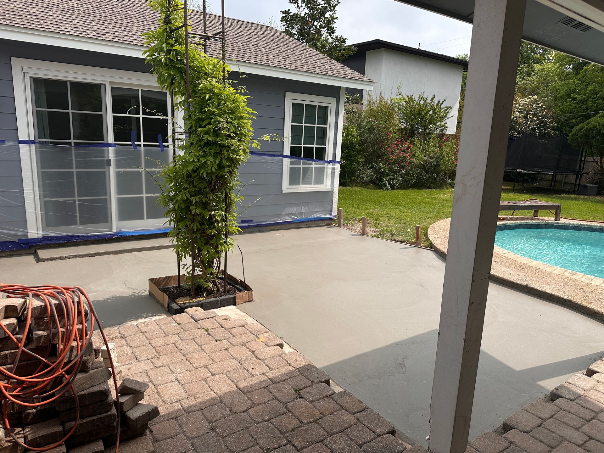 A patio with a table and chairs in the backyard of a house.