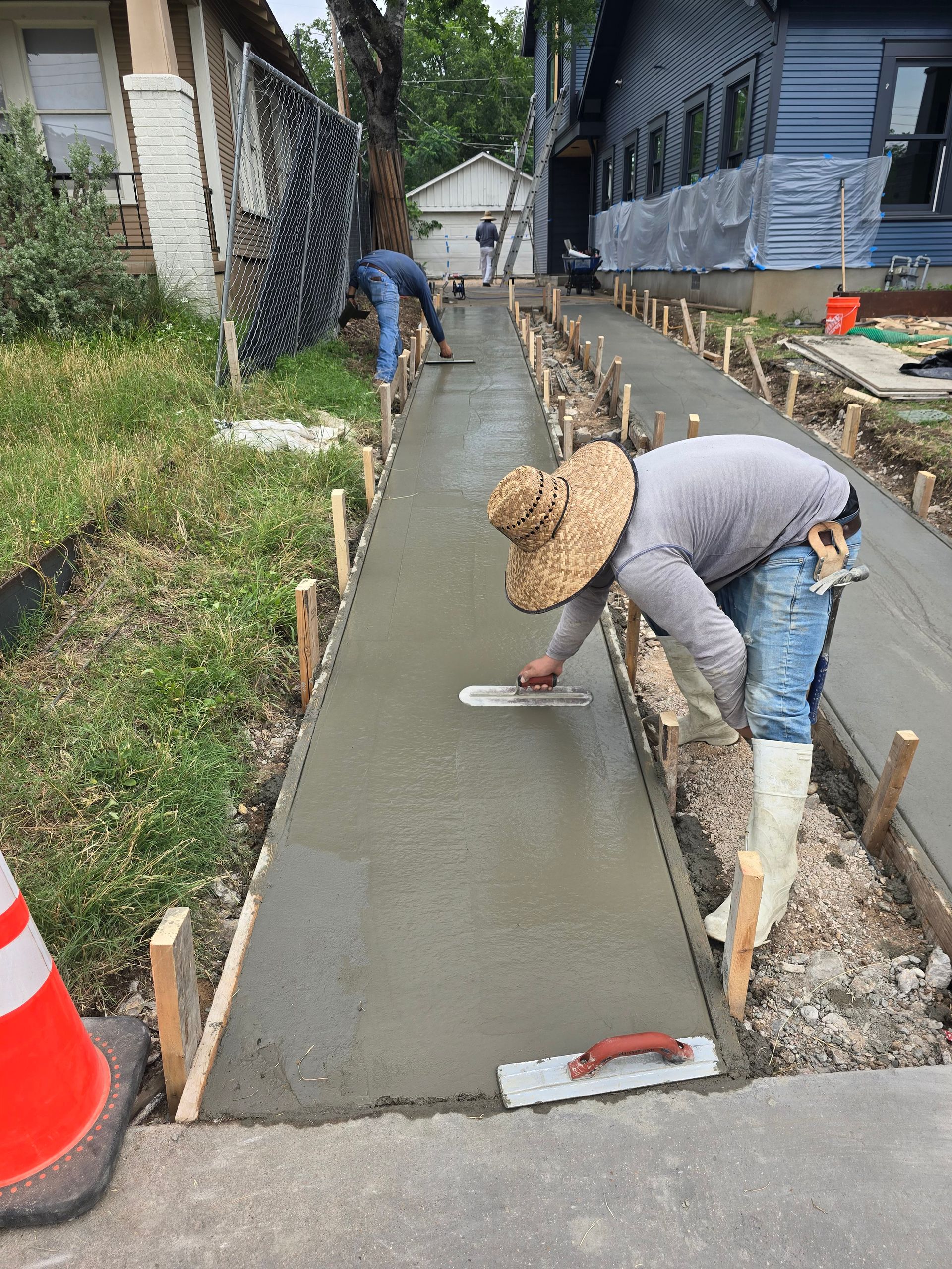 A curved concrete walkway in a park surrounded by grass and trees.