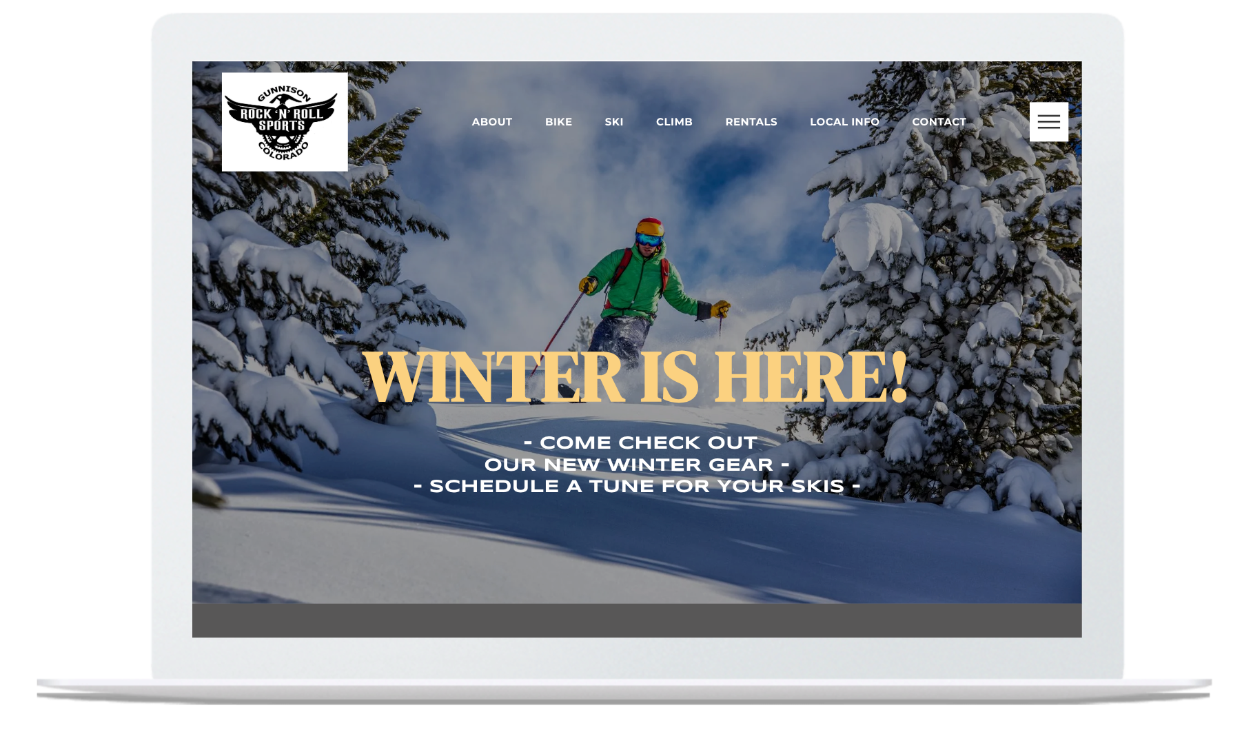 Laptop displaying a winter sports website with snowy mountain scene.