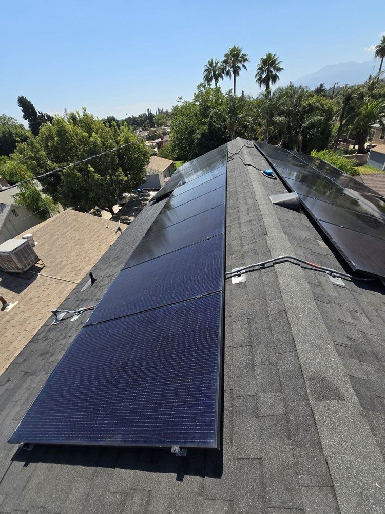 A row of solar panels are sitting on top of a roof.