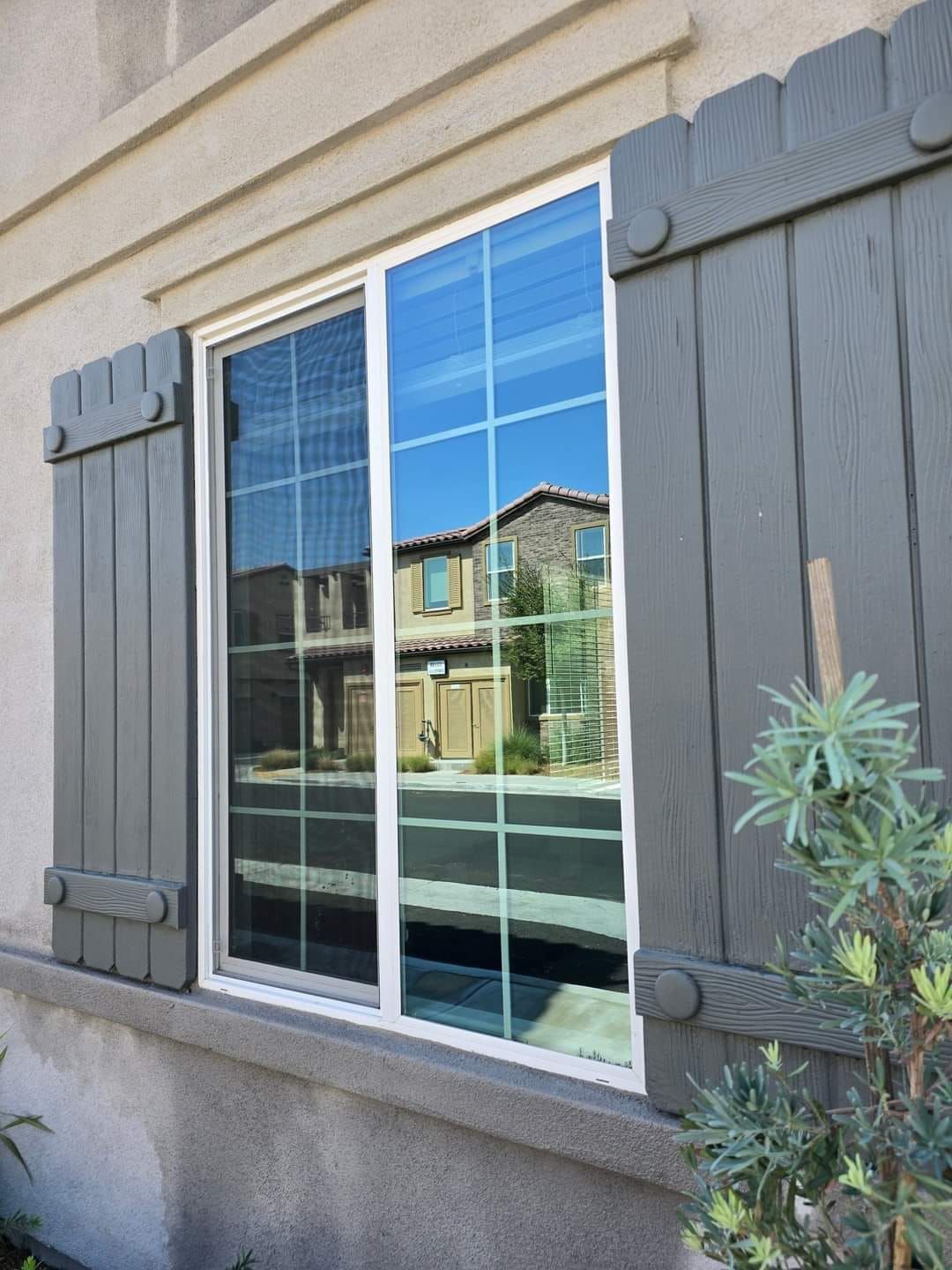 A window with a reflection of a house in it