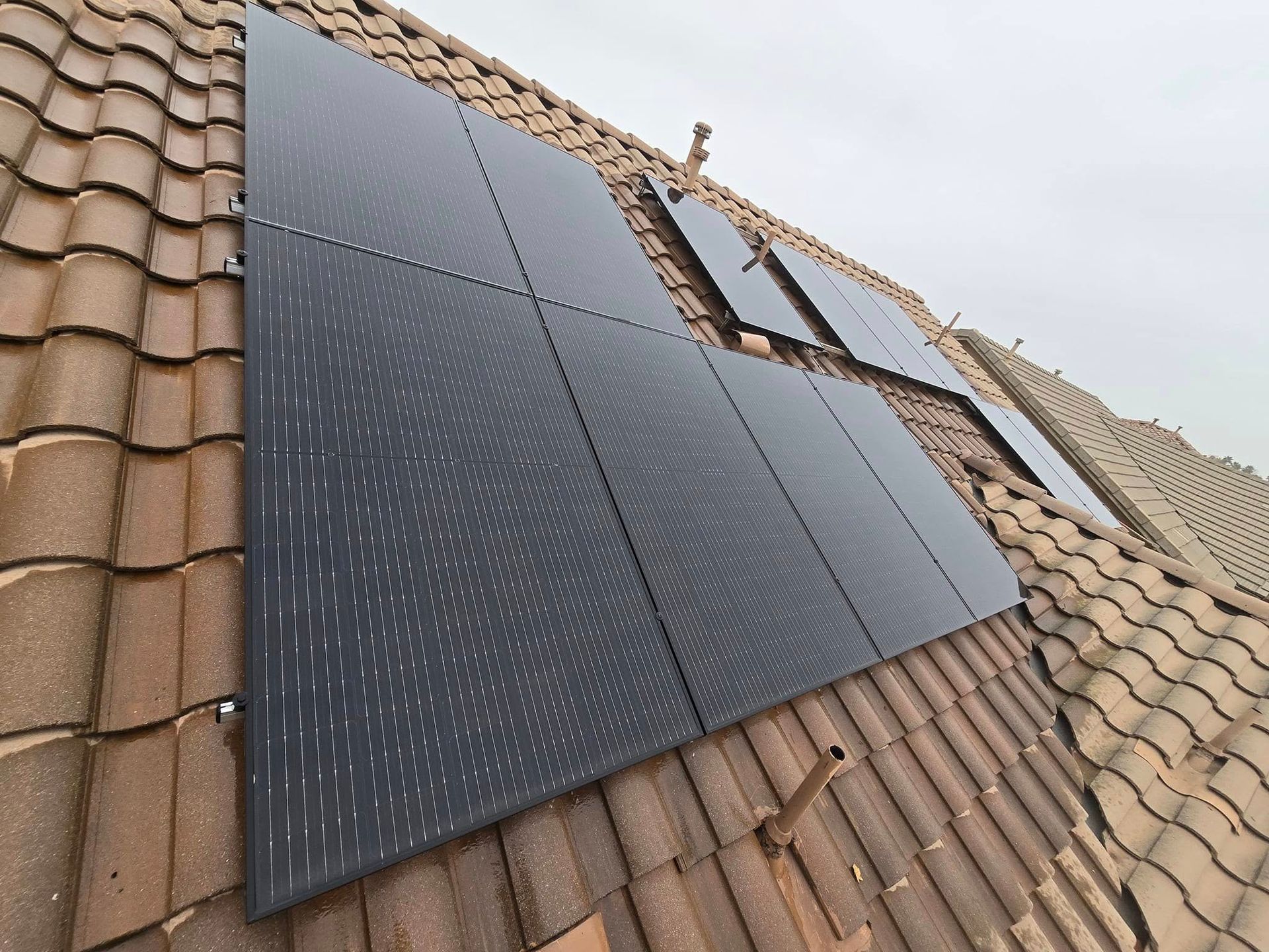 A row of solar panels on a tiled roof