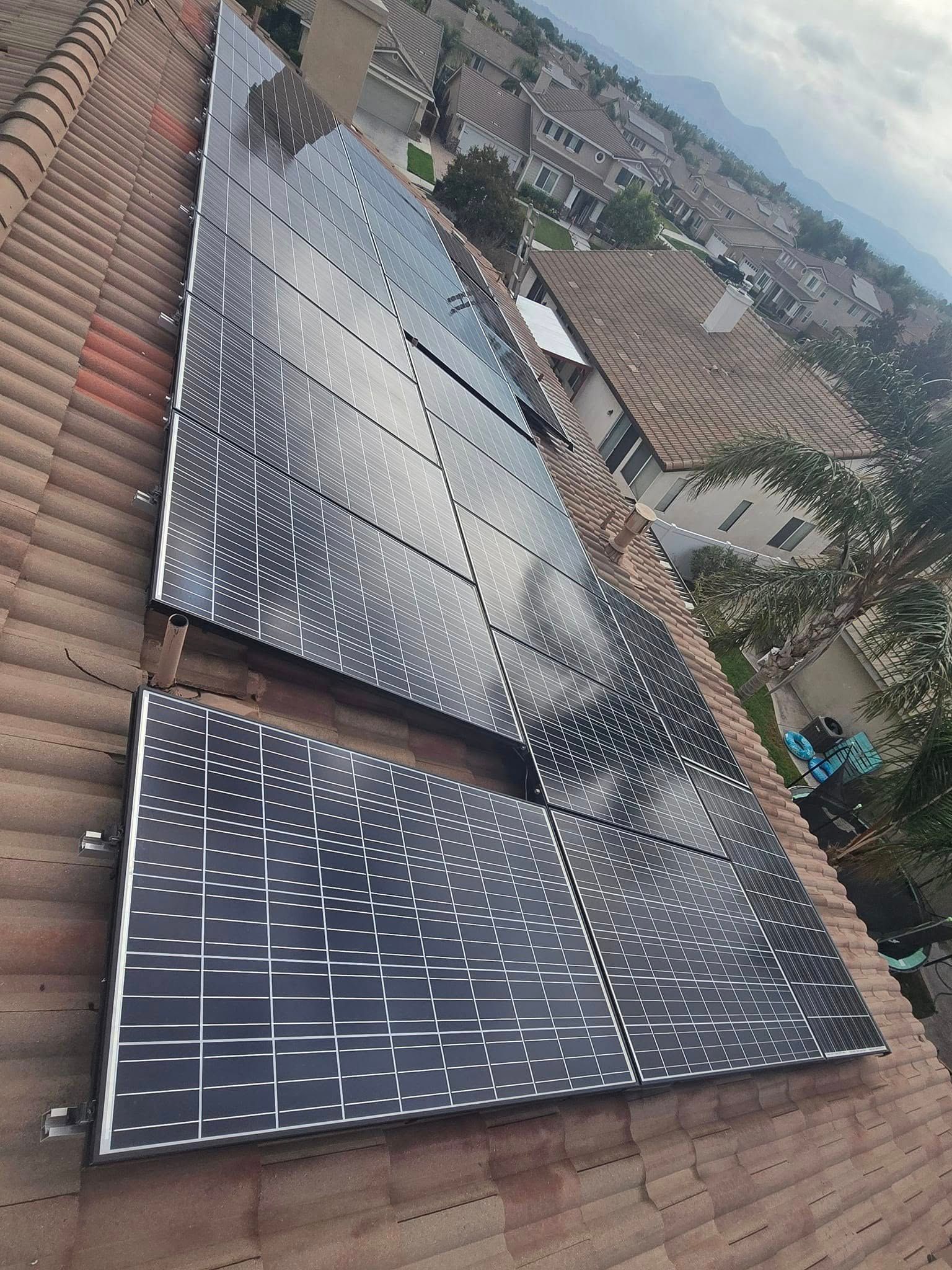 A row of solar panels are sitting on top of a tiled roof.