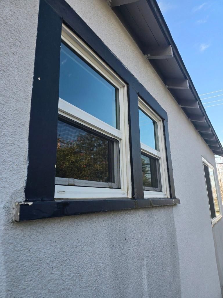 A house with two windows on the side of it