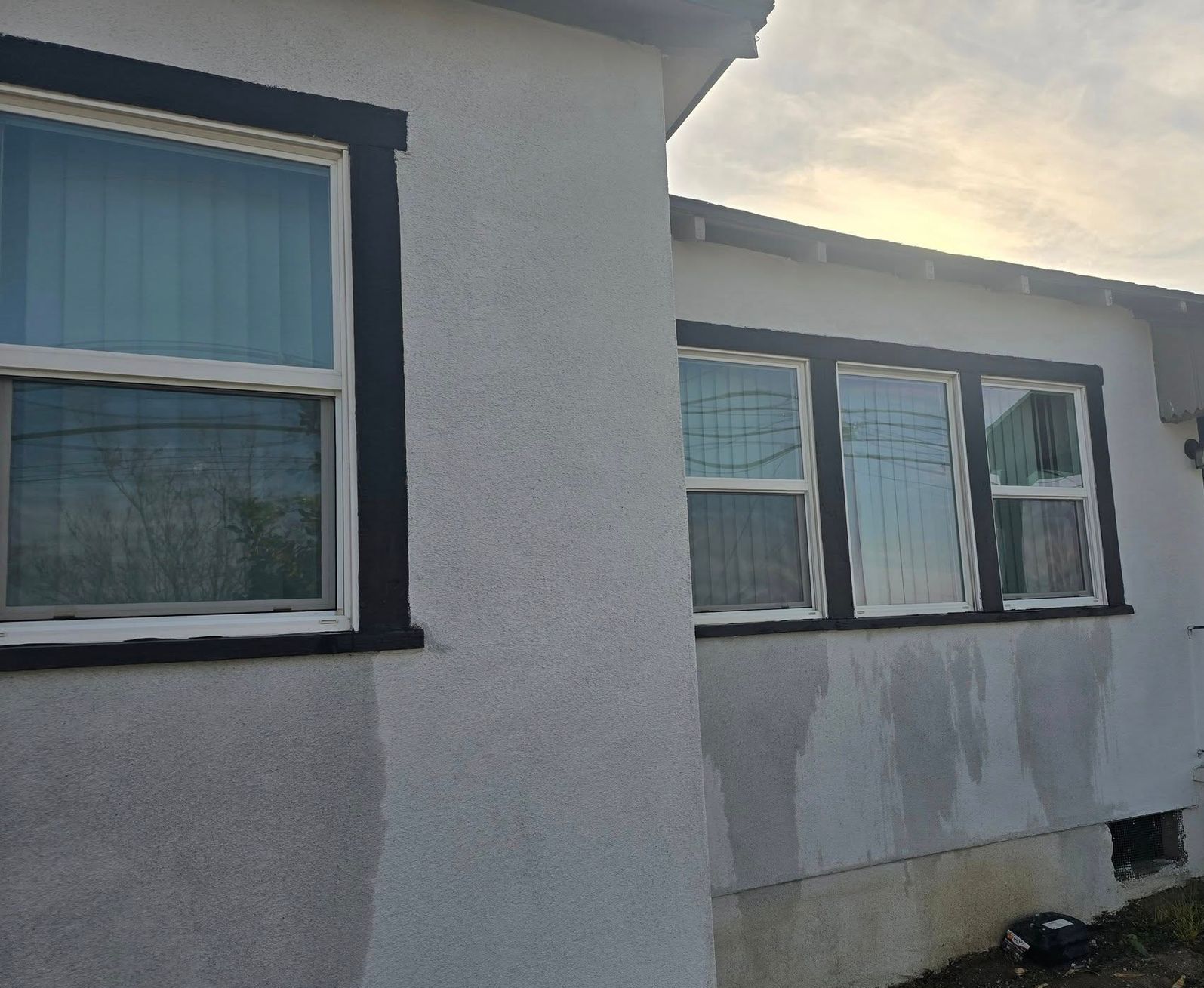 A white house with black trim and a lot of windows