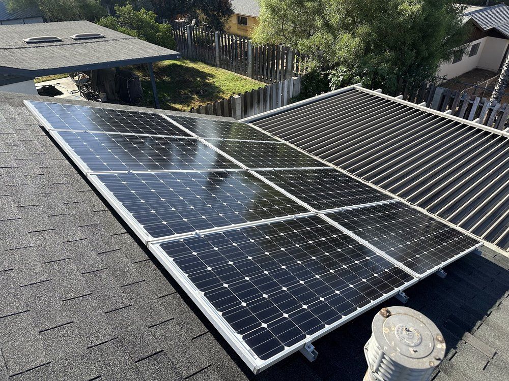 A row of solar panels are sitting on top of a roof.