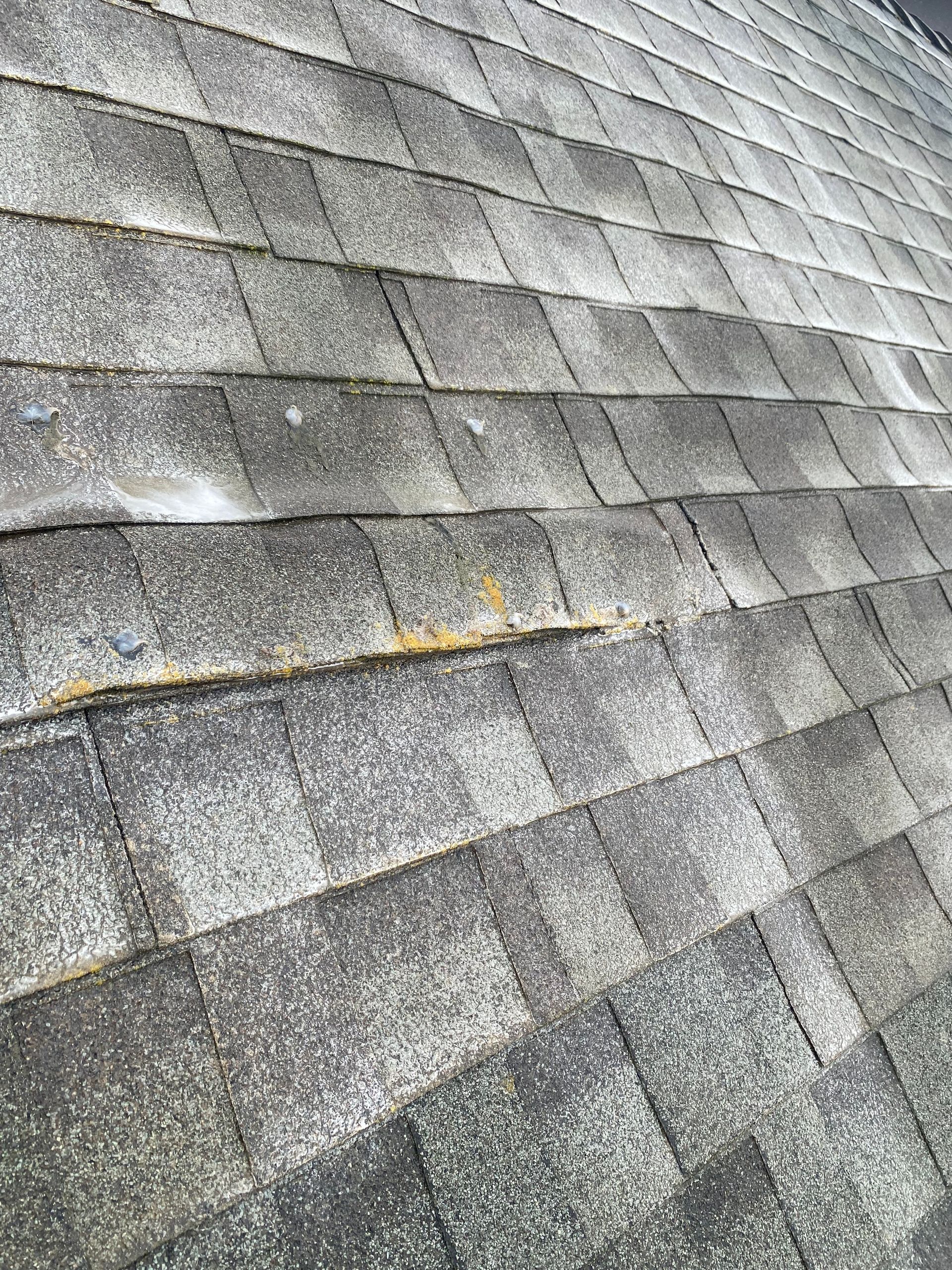 A close up of a roof with shingles that are peeling off.