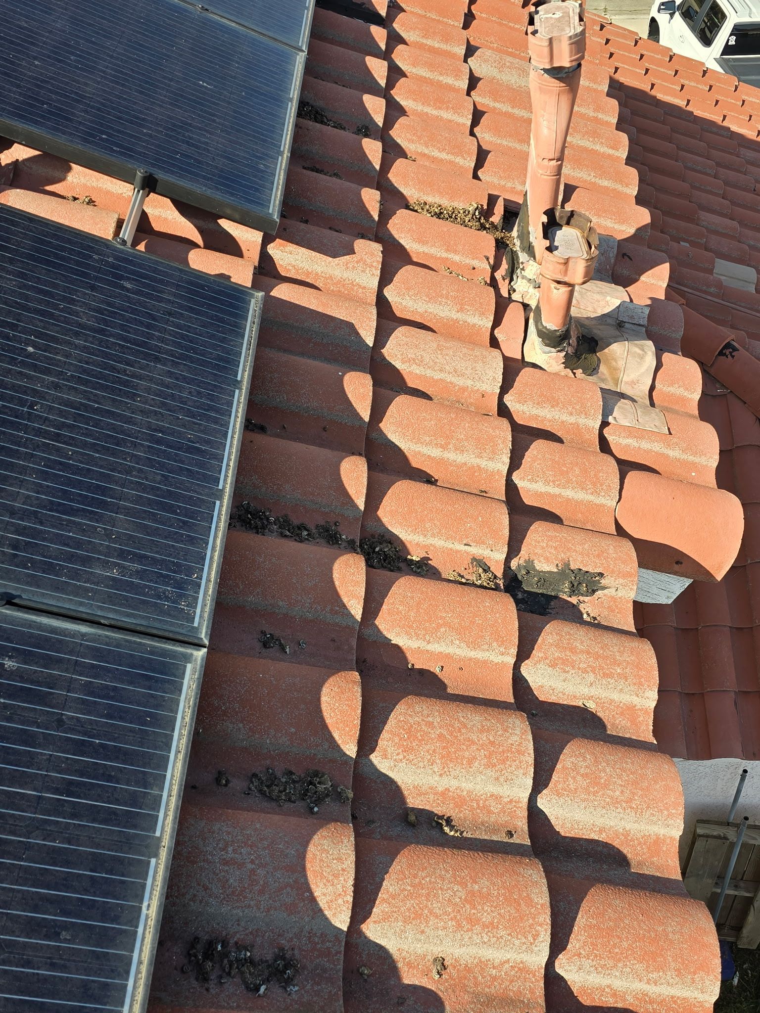 A roof with a lot of tiles and solar panels on it.