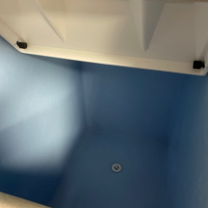 White ceiling corner with blue walls and a small white circular light.