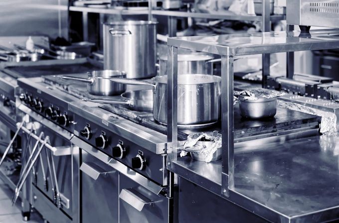 Commercial kitchen with stainless steel appliances and pots.