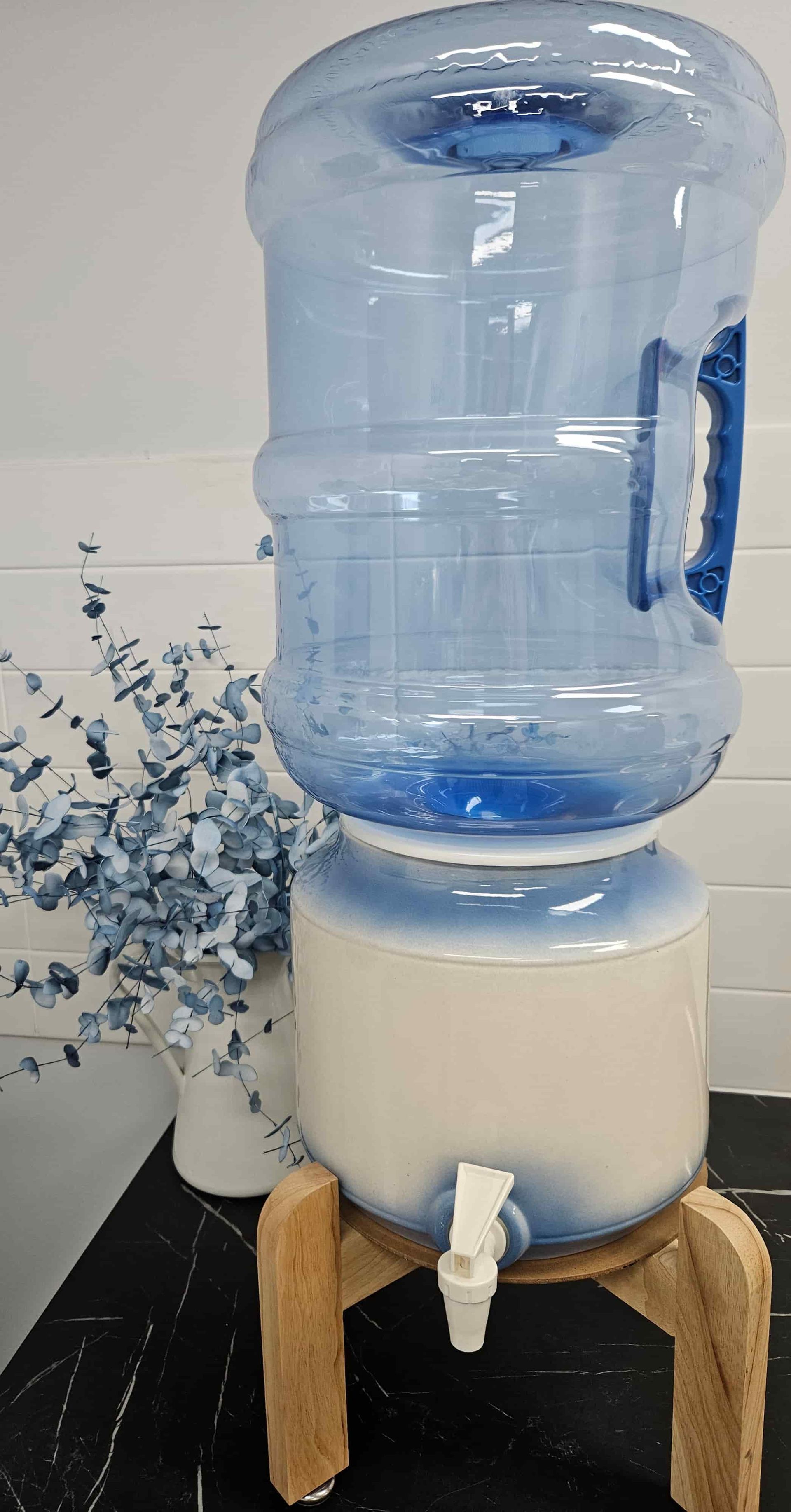 A Large Plastic Water Bottle Is Sitting On Top Of A Wooden Stand — Billabong Springs in Brisbane, QLD