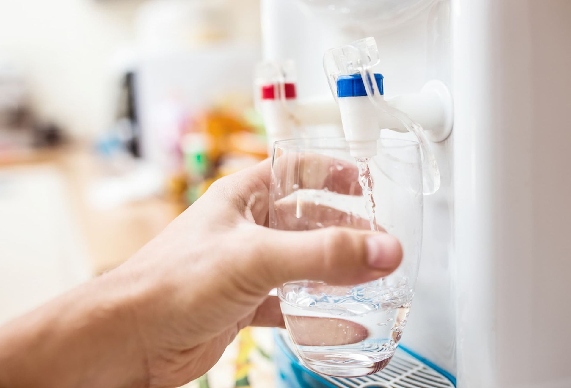 A Person Is Pouring Water Into a Glass from A Water Dispenser — Billabong Springs in Jimboomba, QLD