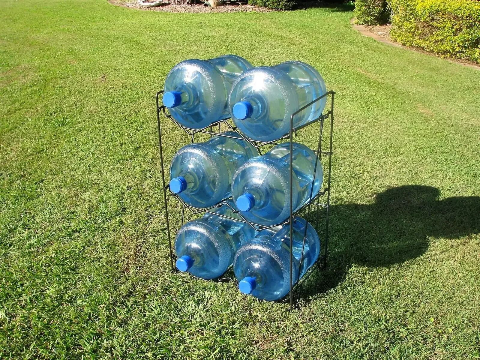 A Rack Of Water Bottles Sitting On Top Of A Lush Green Field — Billabong Springs in Jimboomba, QLD