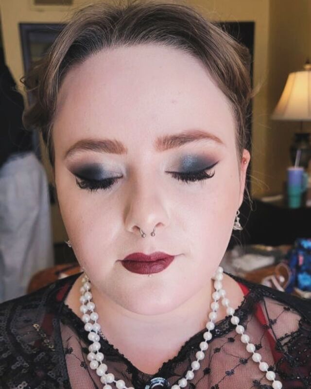 A close up of a woman wearing makeup and a pearl necklace