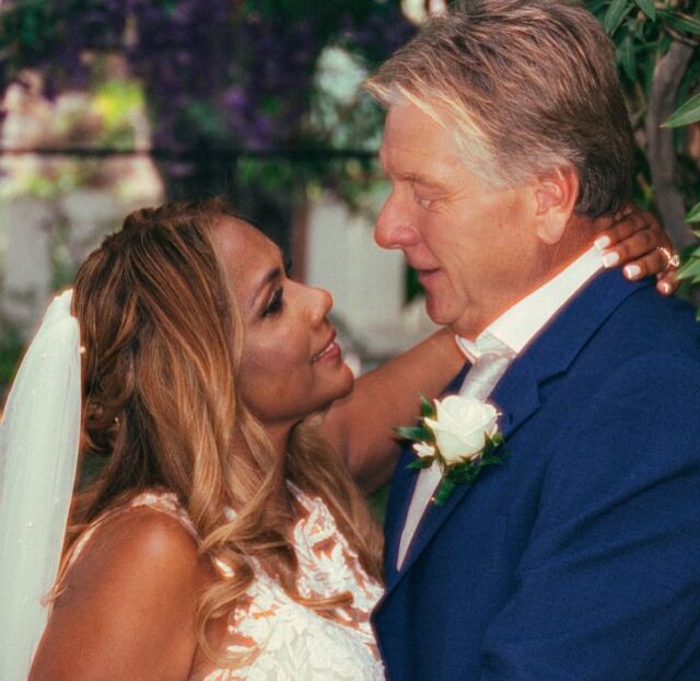A bride and groom are looking into each other 's eyes on their wedding day.