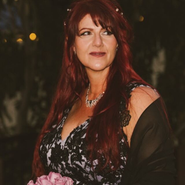 A woman with red hair is wearing a black and white dress