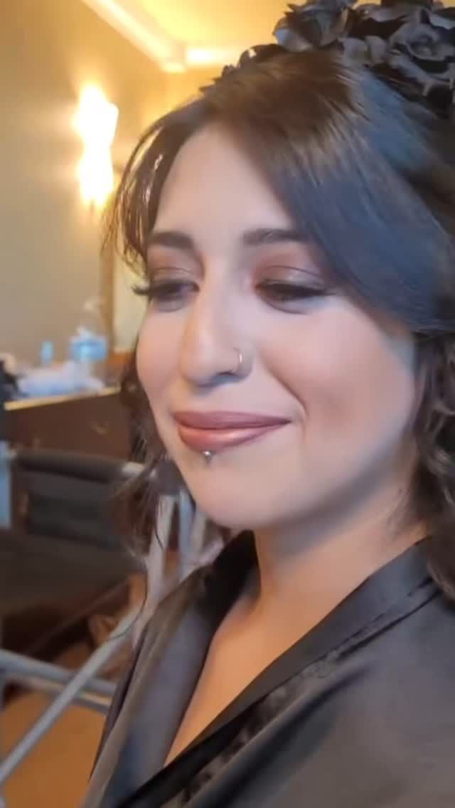 A close up of a woman 's face with a flower in her hair
