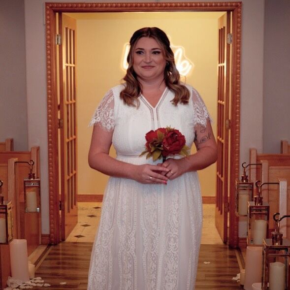 A woman in a white dress is holding a bouquet of flowers