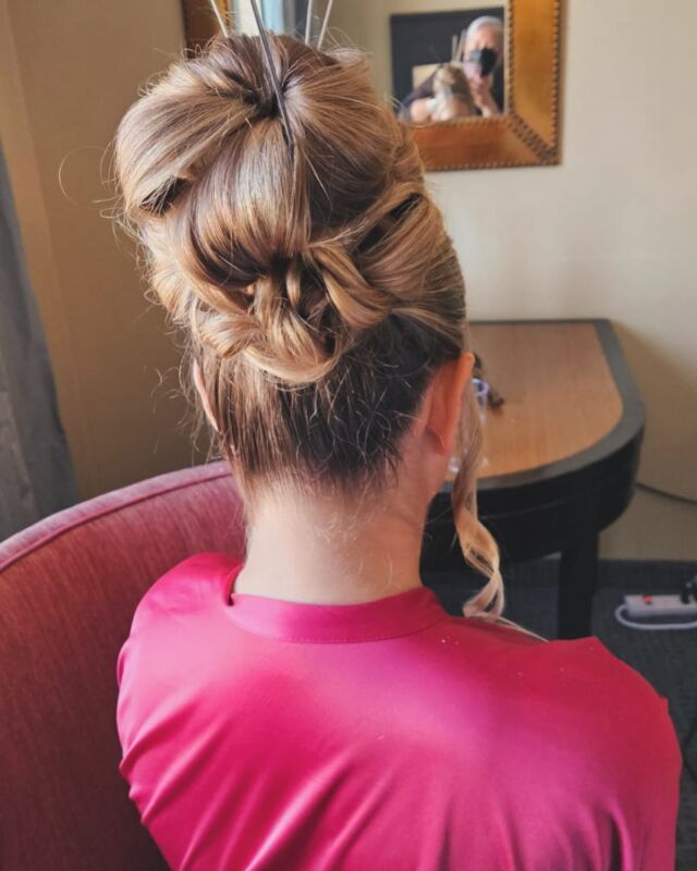 A woman in a pink robe has her hair in a bun