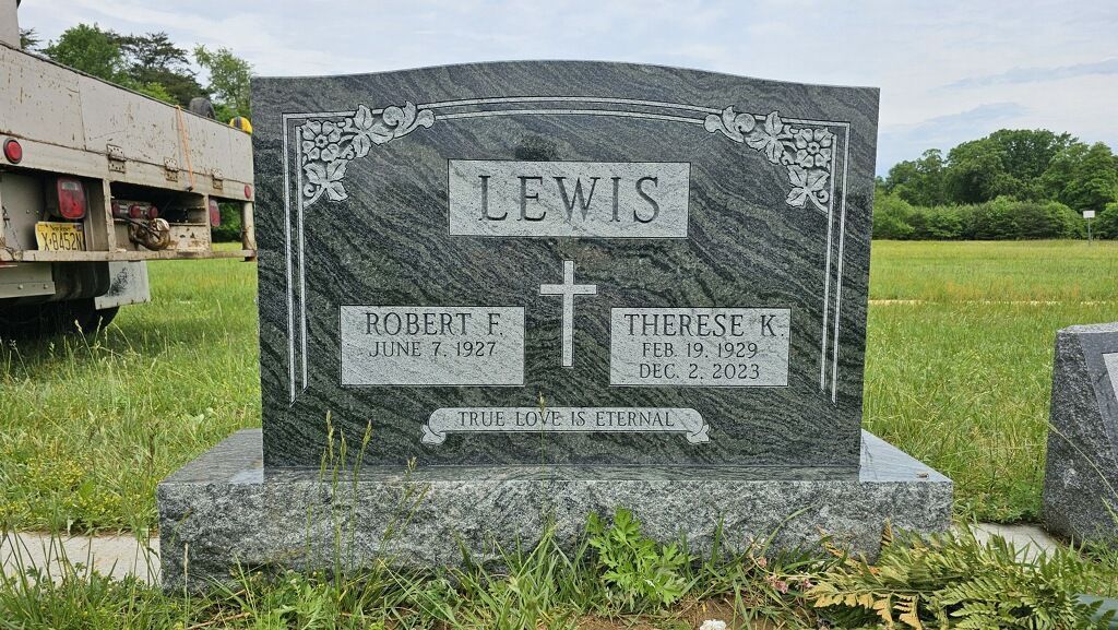 A dark grey granite headstone engraved with the surname 