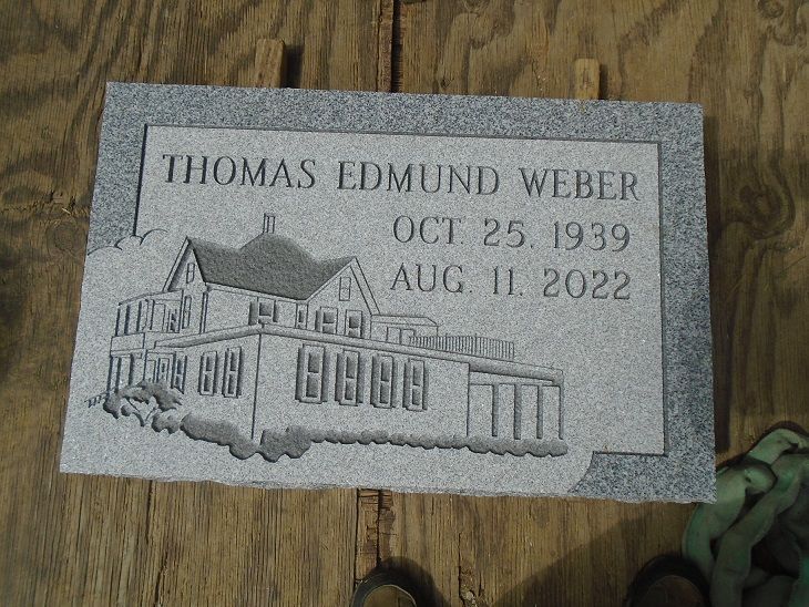 A grey granite headstone engraved with 