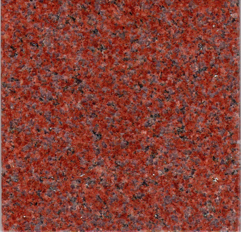 A close-up of a polished granite slab with a fine-grained texture in shades of red, orange, and flecks of dark gray.