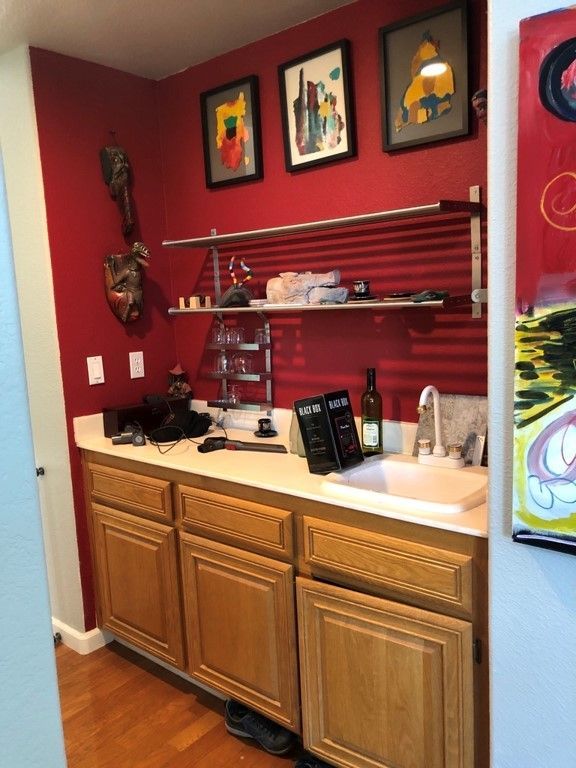 A kitchen with a sink and a red wall