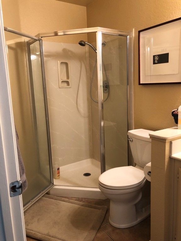 A bathroom with a toilet and a shower stall