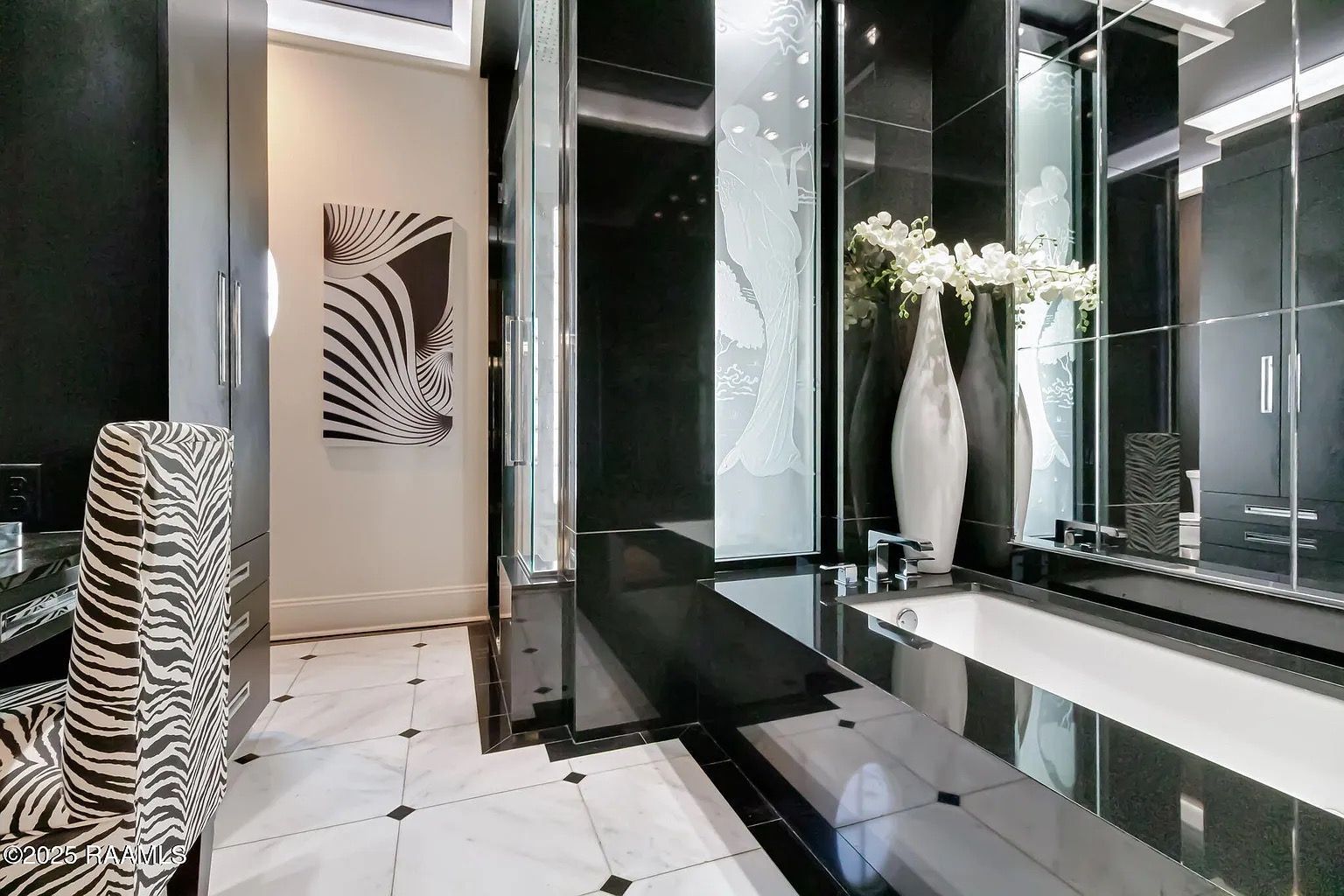 A bathroom with black and white tiles and a zebra print chair
