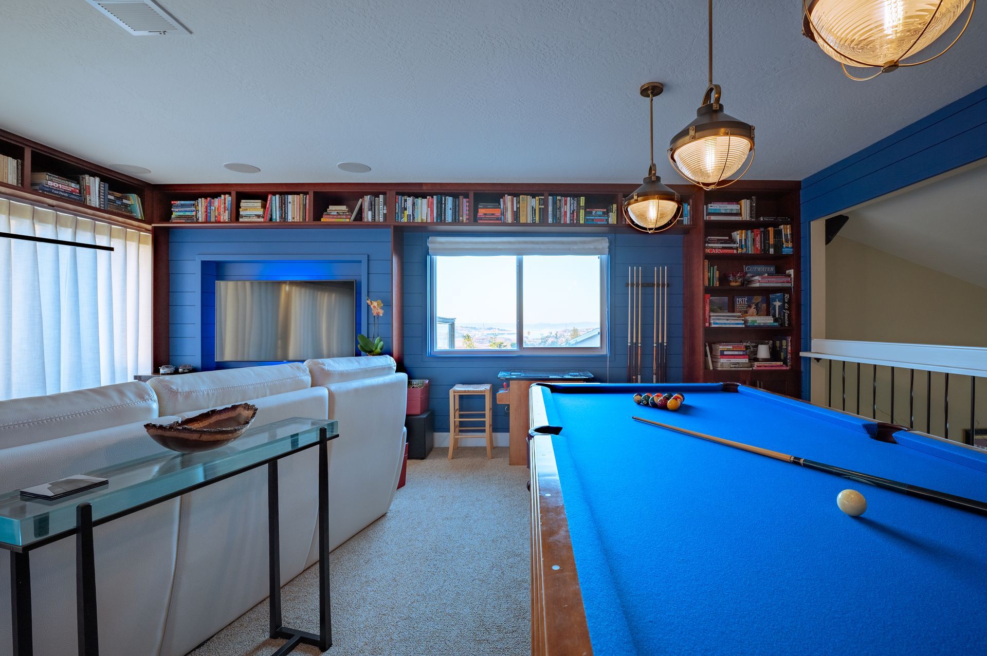 a pool table in a living room next to a couch
