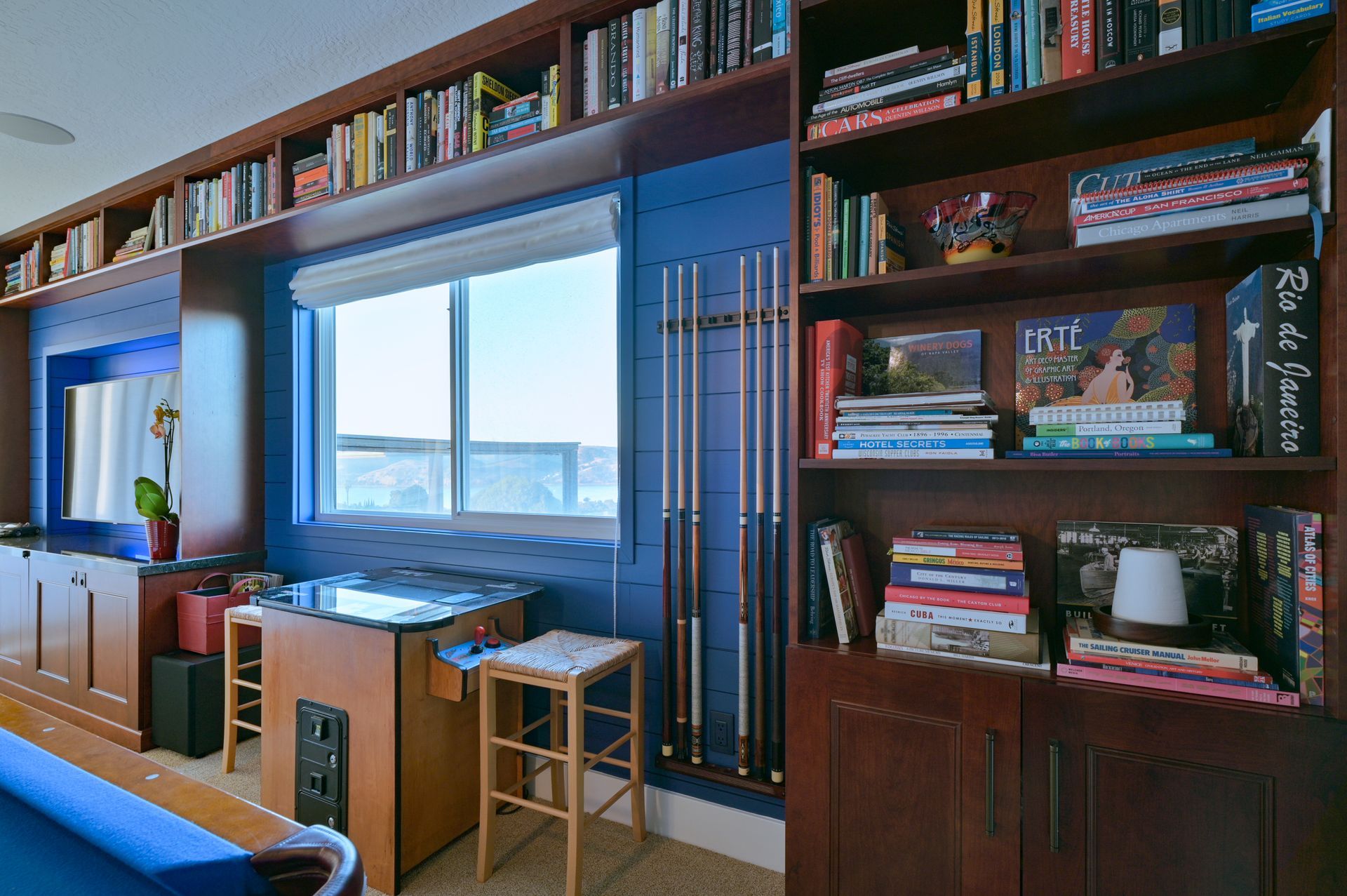 a room with a pool table and shelves full of books