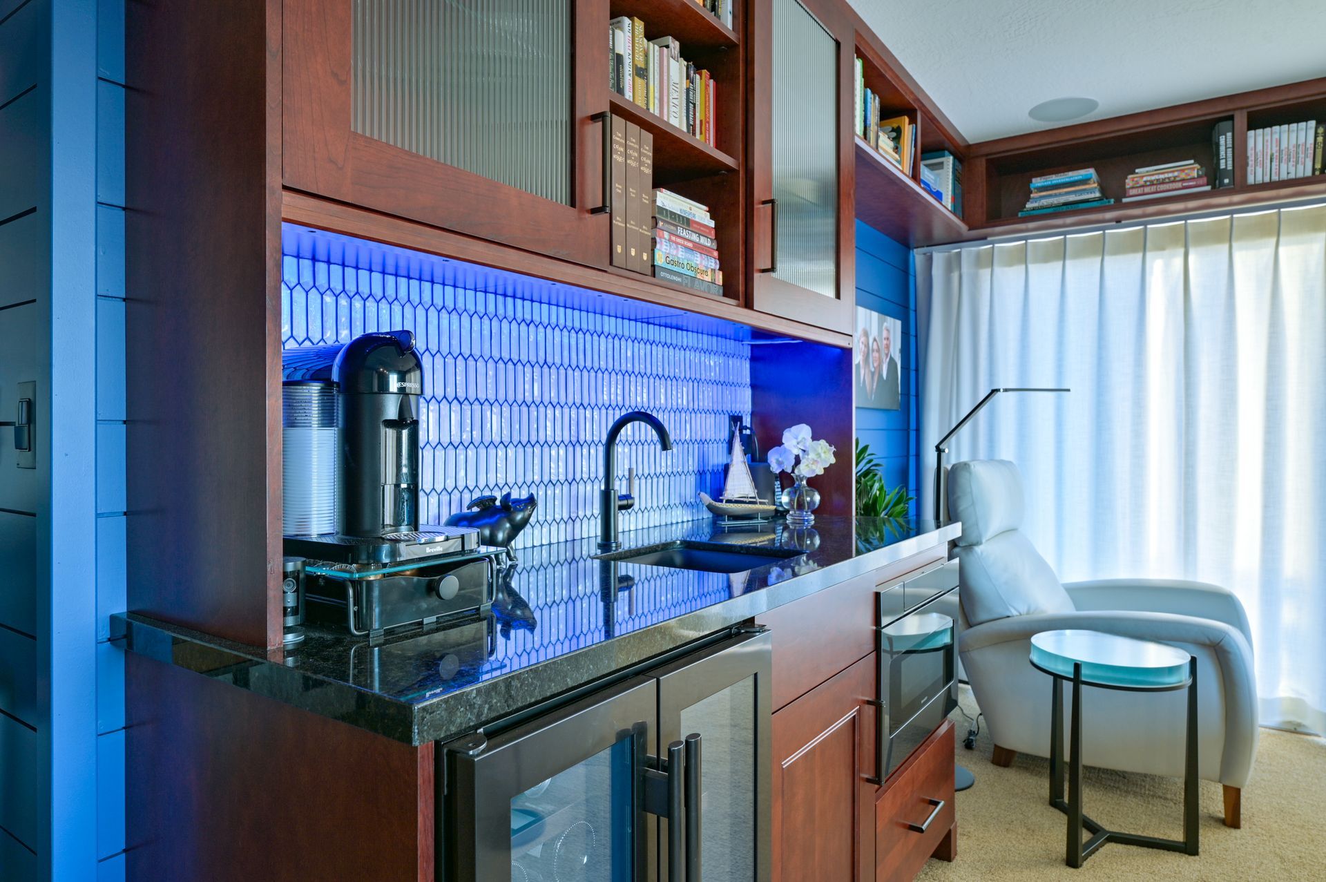 a kitchen with a sink and a refrigerator in a living room