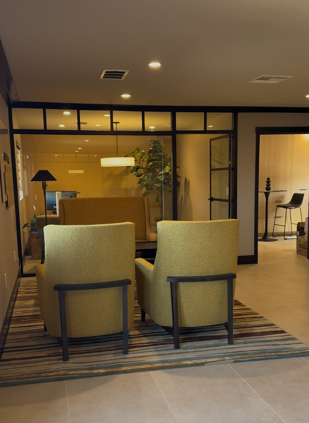 A living room with two yellow chairs and a rug