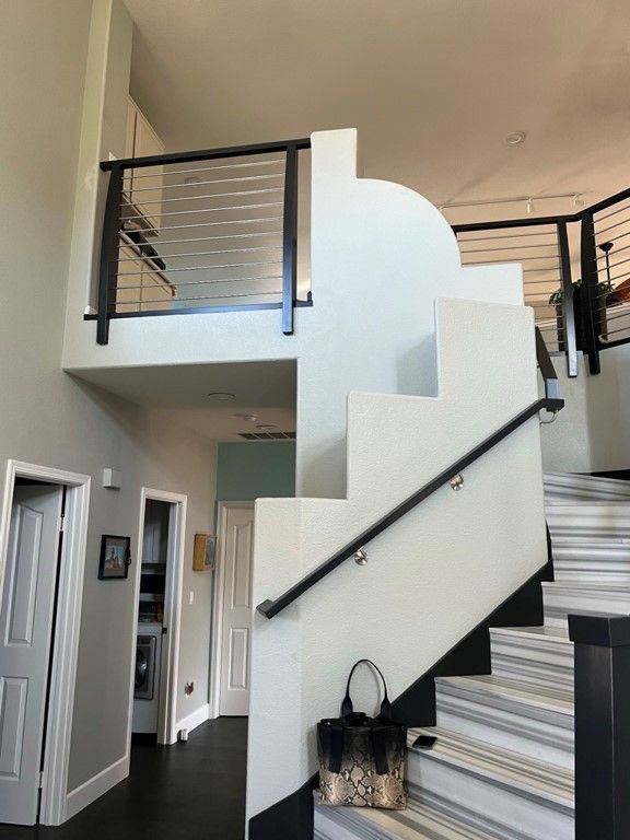 A staircase in a house with a black railing