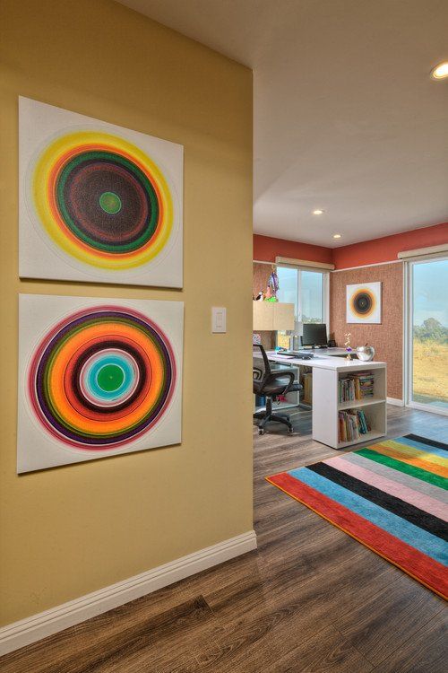 A room with two paintings on the wall and a rug