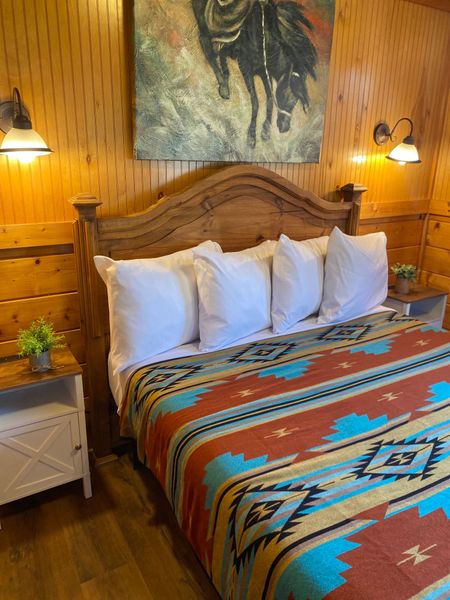 There is a painting of a man riding a horse on the wall above the bed.