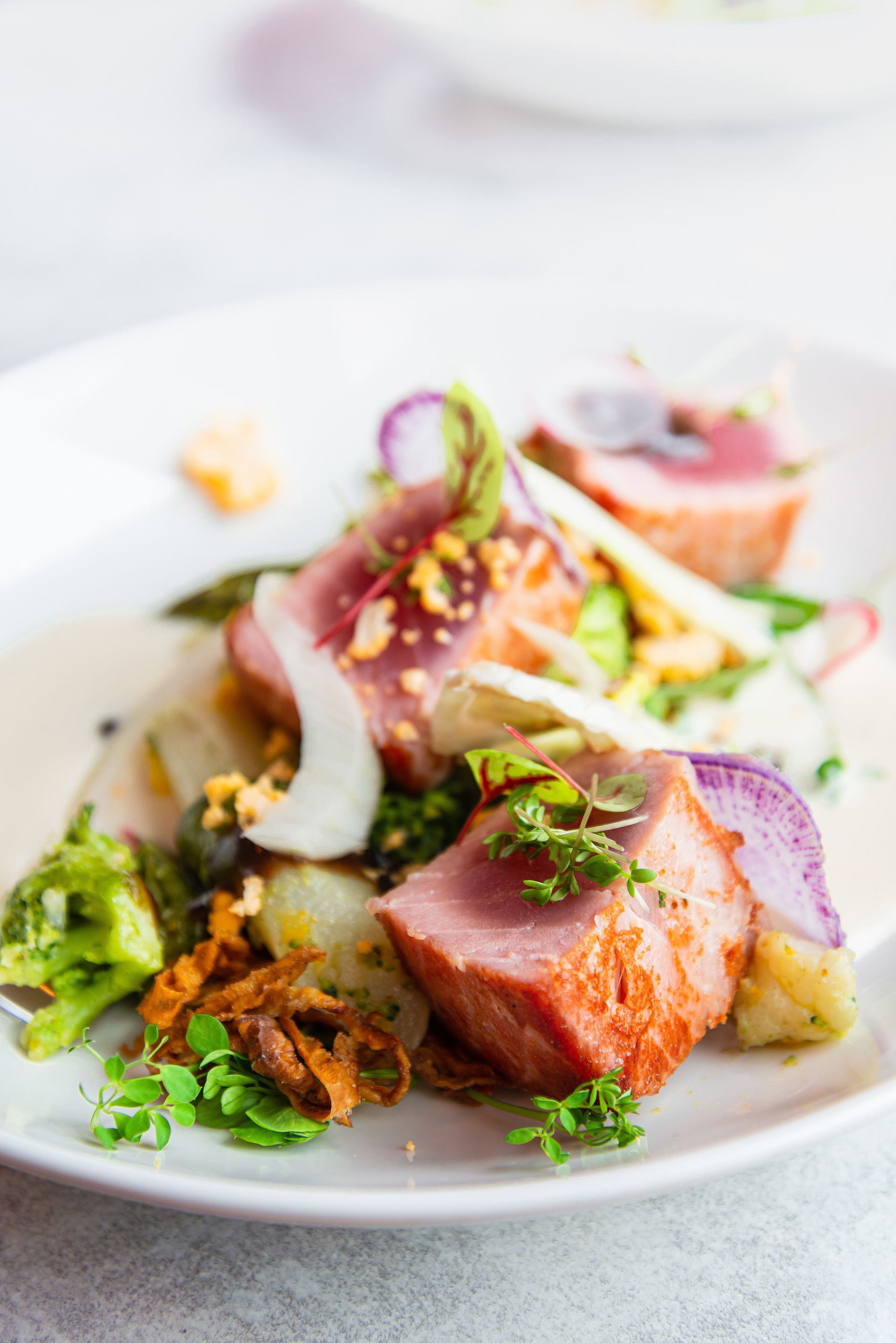 A basket of fried chicken and potato wedges on a wooden table.