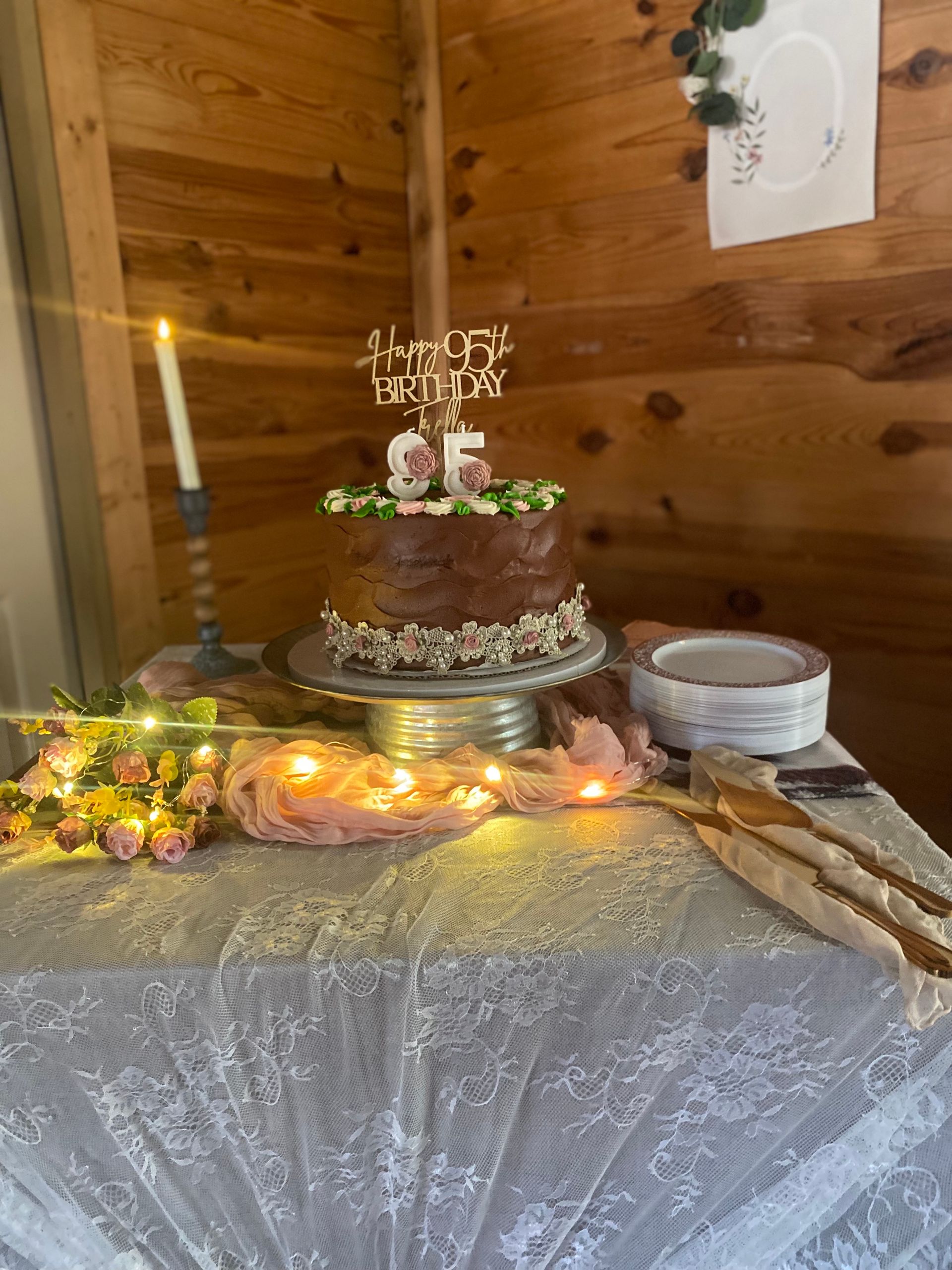 A cake is sitting on top of a table next to a candle.