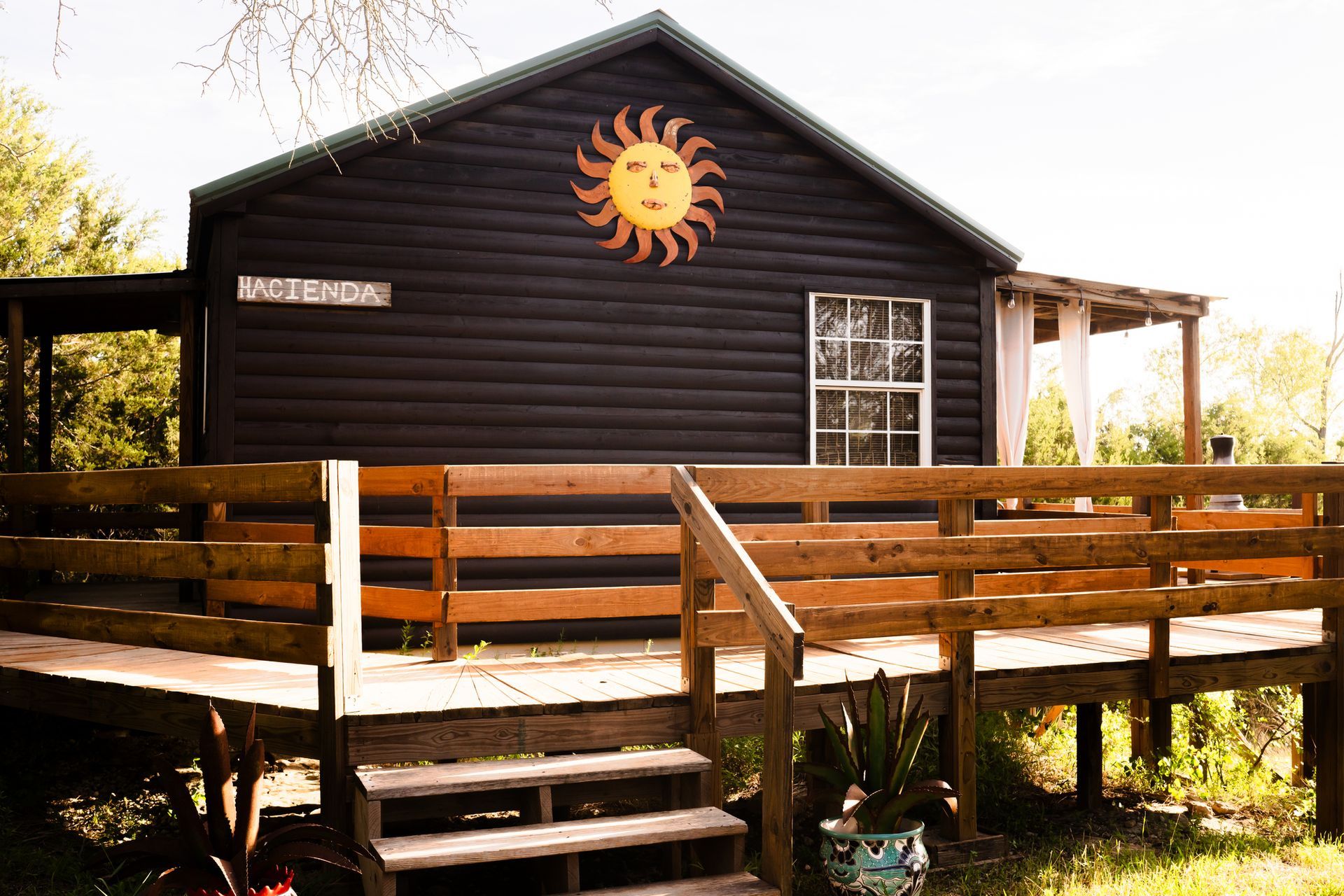 A small house with a wooden deck and stairs leading to it