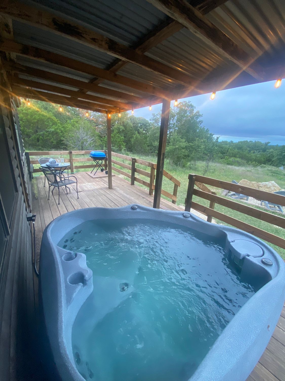 A hot tub is sitting on top of a wooden deck.