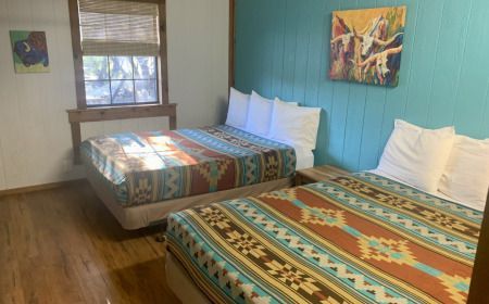 A hotel room with two beds and a window.