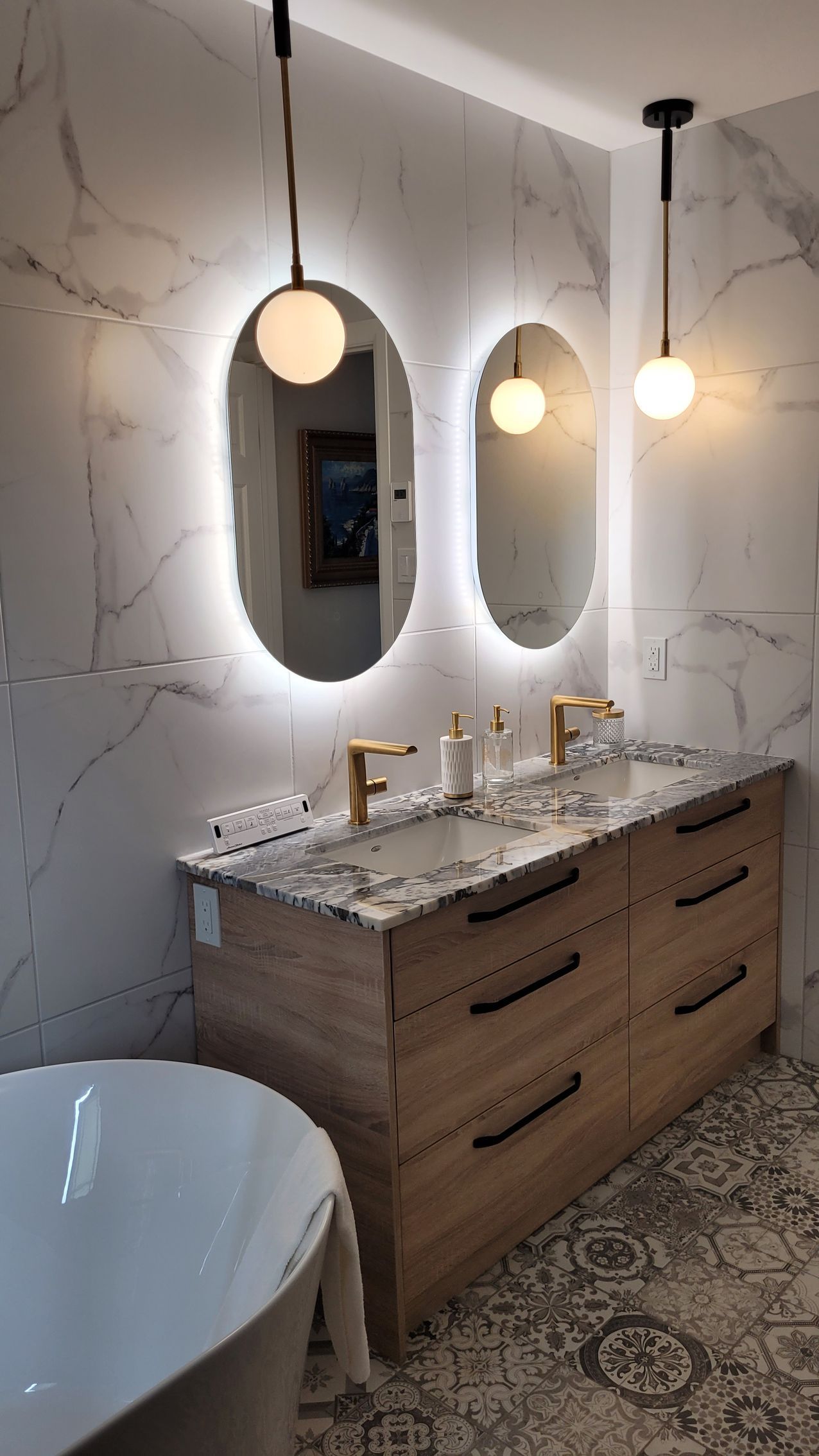 Une salle de bain avec deux lavabos, deux miroirs et une baignoire.